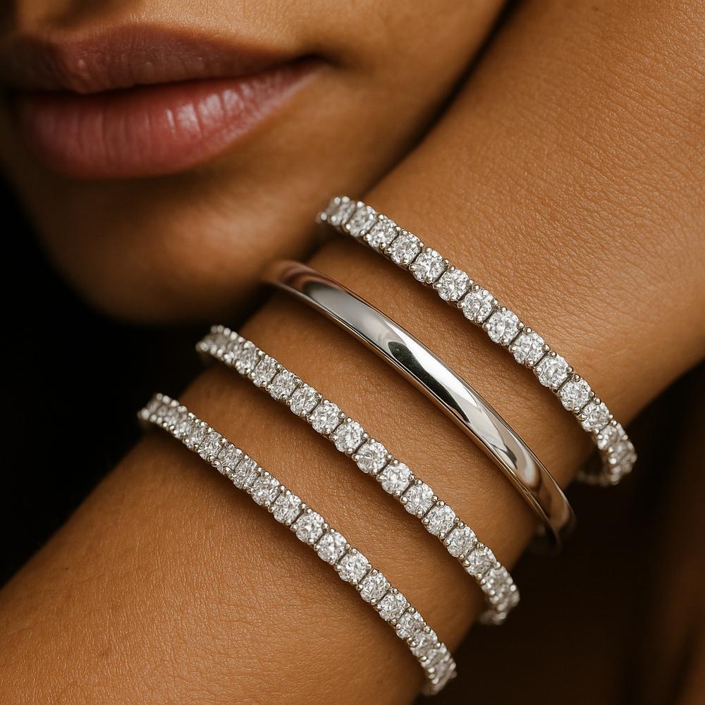 Elegant white gold jewelry including rings, bracelets, and necklaces displayed on a velvet tray