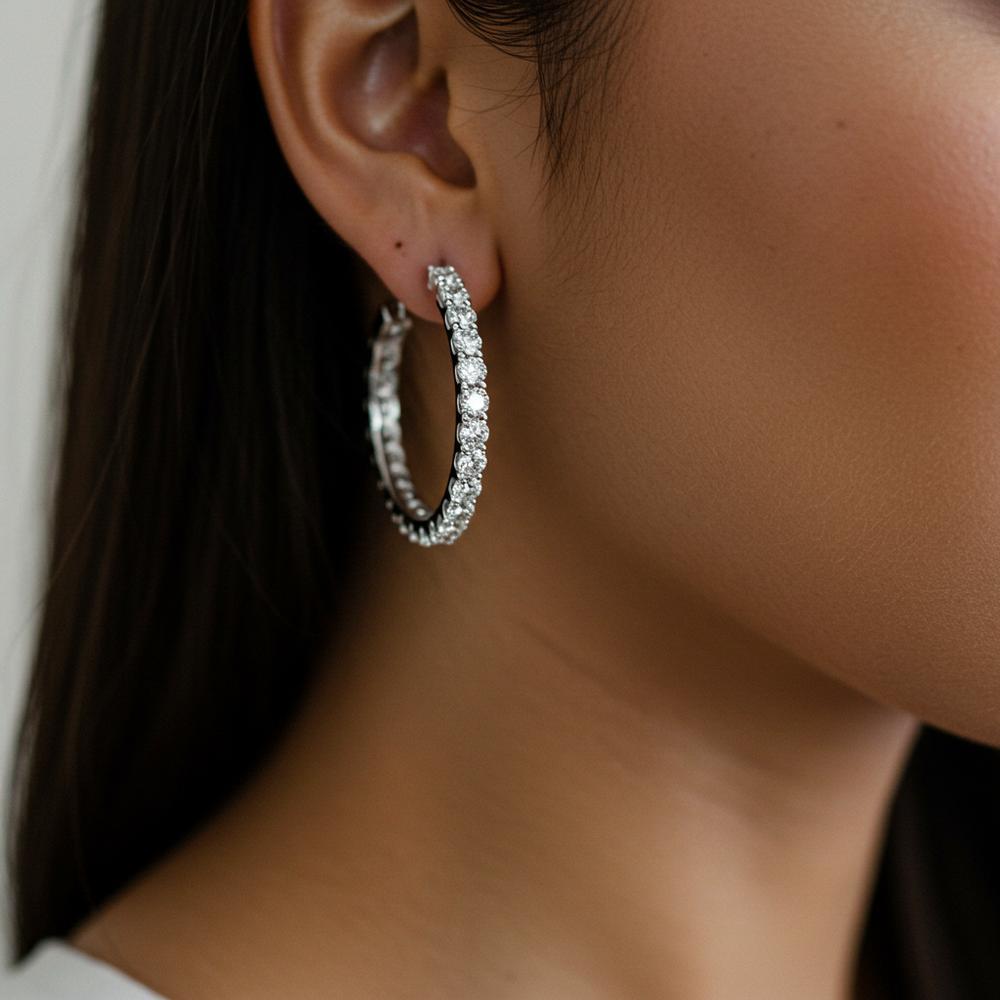 Woman wearing stylish gold hoop earrings with an elegant outfit.