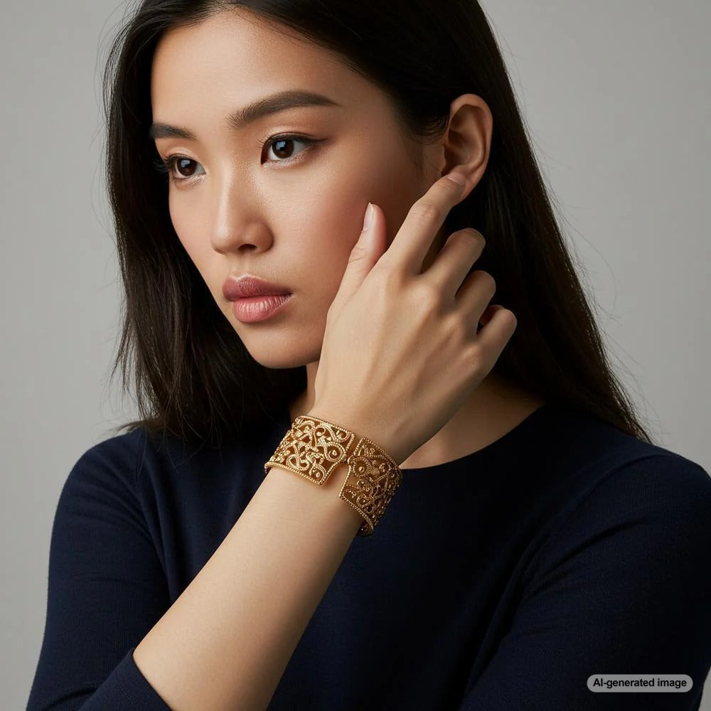 Elegant gold cuff bracelet on a marble surface, showcasing its timeless appeal.