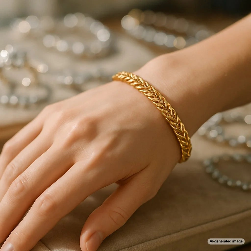 Close up detail of an intricate gold wheat chain necklace, showcasing its woven pattern and brilliant shine.