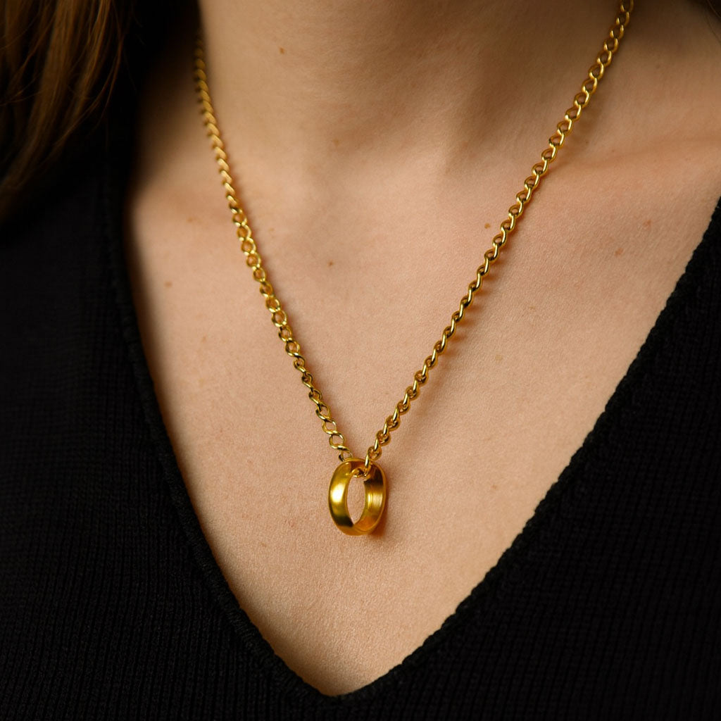 A stunning close-up of a diamond wedding ring hanging from an elegant gold chain, symbolizing love and remembrance