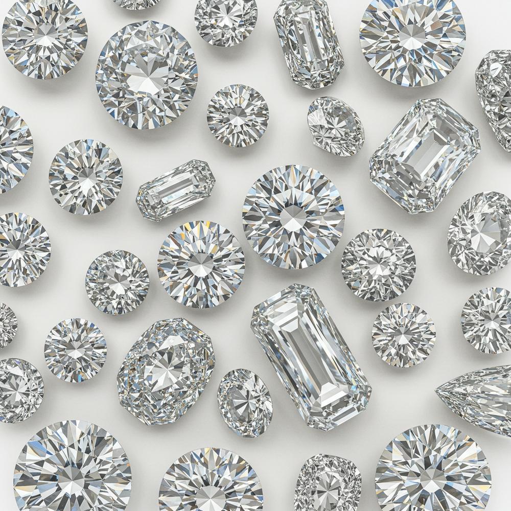 A stunning collection of colorful gemstones including diamonds, rubies, emeralds, and sapphires displayed on velvet.