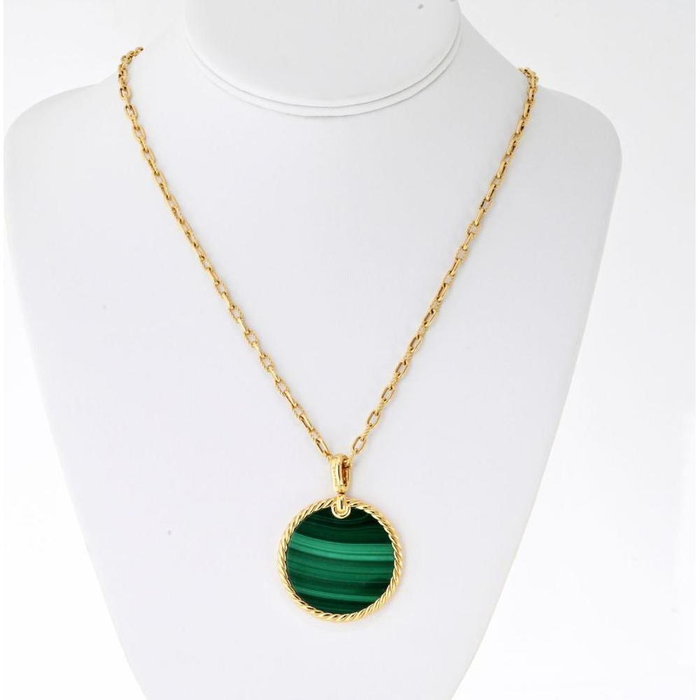 Close-up of a stunning malachite gemstone showing its characteristic green swirls and bands, set in elegant jewelry