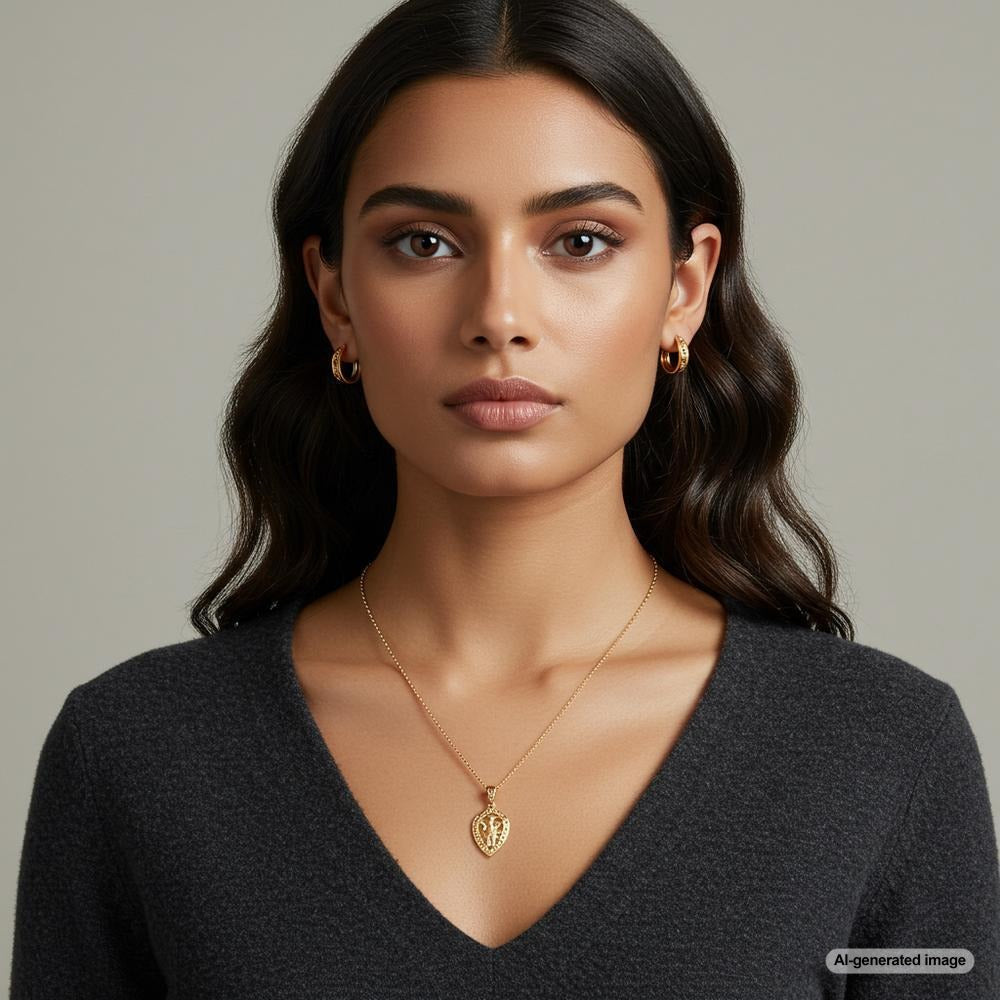A stunning woman with brown eyes wearing gold jewelry, including earrings and a necklace, that enhance her natural beauty.