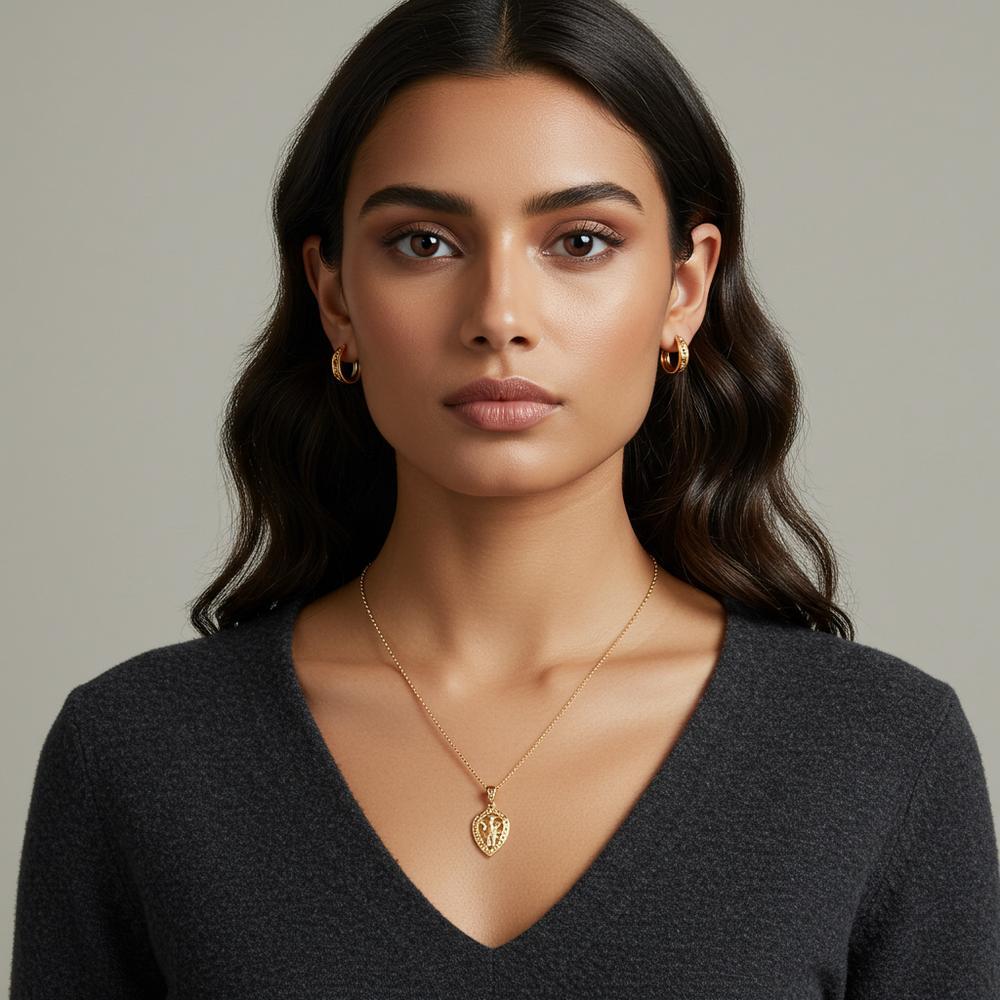 A stunning woman with brown eyes wearing gold jewelry, including earrings and a necklace, that enhance her natural beauty.