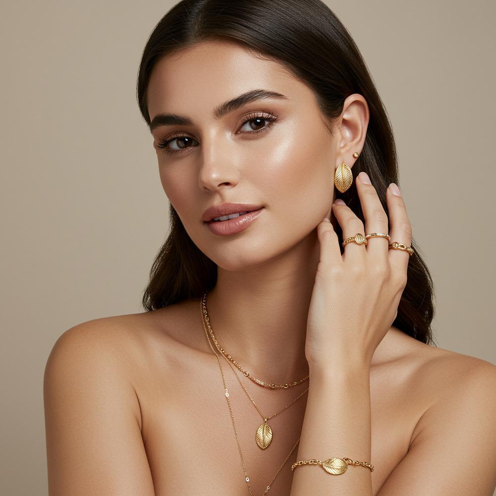 A stunning brunette model showcasing gold jewelry, highlighting the perfect match of warm gold tones with dark hair.