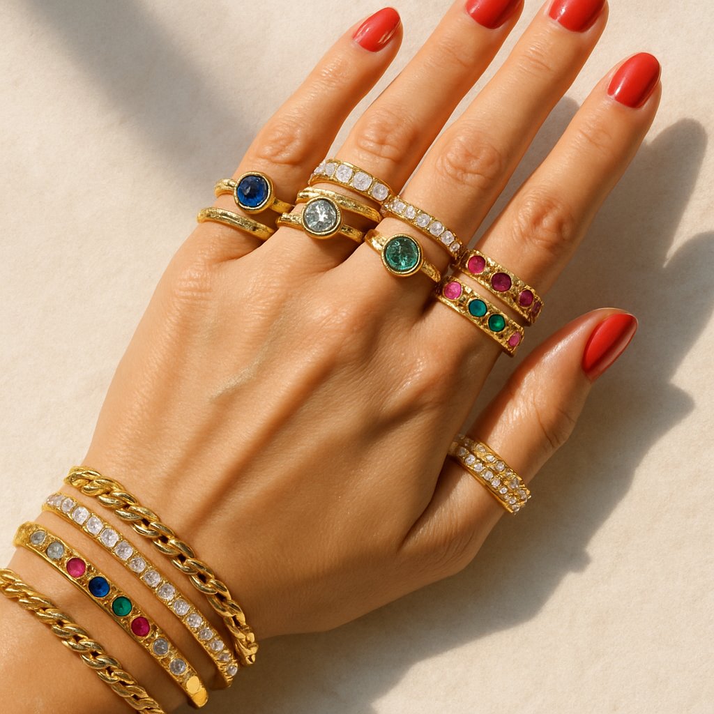 A beautifully stacked collection of rings and bracelets in gold, silver, and rose gold with gemstone accents