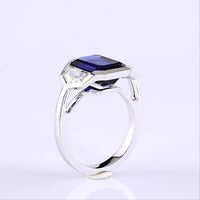 14K White Gold 3-Stone Ring with 6.48 Carats Emerald Cut Lab Blue Sapphire and 1.84 Carats Emerald Cut Lab Diamonds in Half-Bezel Setting - 8.32 Carats Total Gem Weight - Covaloro Fine Jewelry