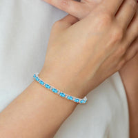 14K White Gold 7" Tennis Bracelet with Oval Swiss Blue Topaz and Round Diamonds - 0.56 Carats Total Topaz Weight by Monteluci Fine Jewelry