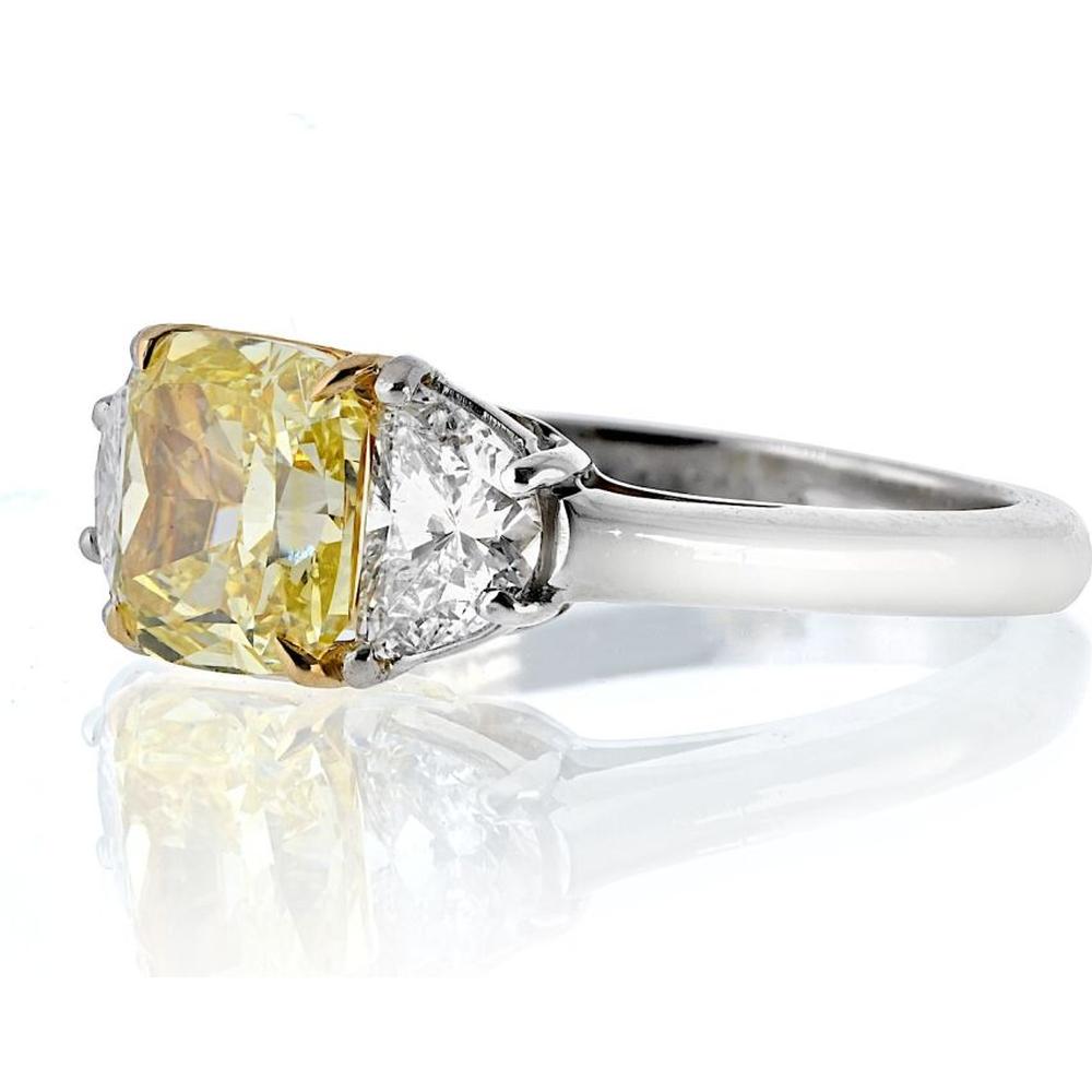 Platinum and 18K Yellow Gold 3-Stone Ring with 2.16 Carats GIA Certified Fancy Intense Yellow Radiant Cut Diamond and Diamond Shields - 0.97 Carats Total Diamond Weight