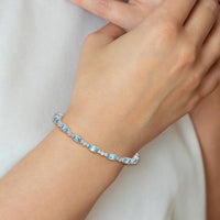 Sterling Silver Rhodium-Plated Tennis Bracelet with Oval Swiss Blue Topaz & Round White Topaz - 0.61 Carat Total Gem Weight by Monteluci Fine Jewelry